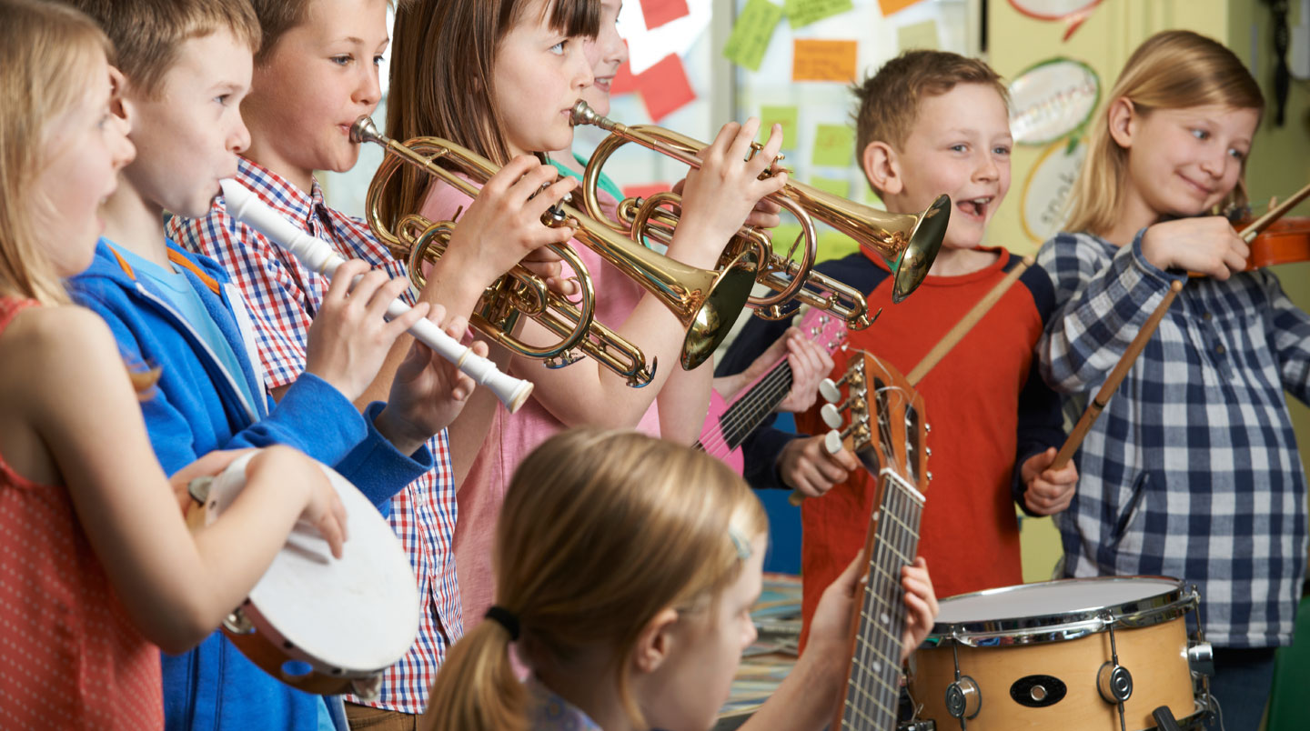 Mains d'un enfant de 2 ans explorant délicatement les cordes d'une contrebasse adaptée lors d'un atelier d'éveil musical bilingue